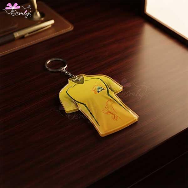 CSK Cricket Jersey keychain in yellow color on a dark wooden desk