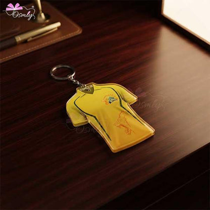 CSK Cricket Jersey keychain in yellow color on a dark wooden desk