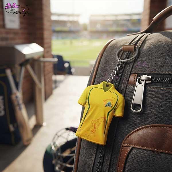 Yellow CSK cricket jersey shaped acrylic keychain attached to a grey backpack