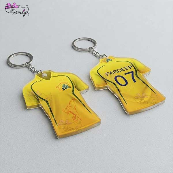 Two yellow CSK cricket jersey shaped acrylic keychains with custom names and numbers.